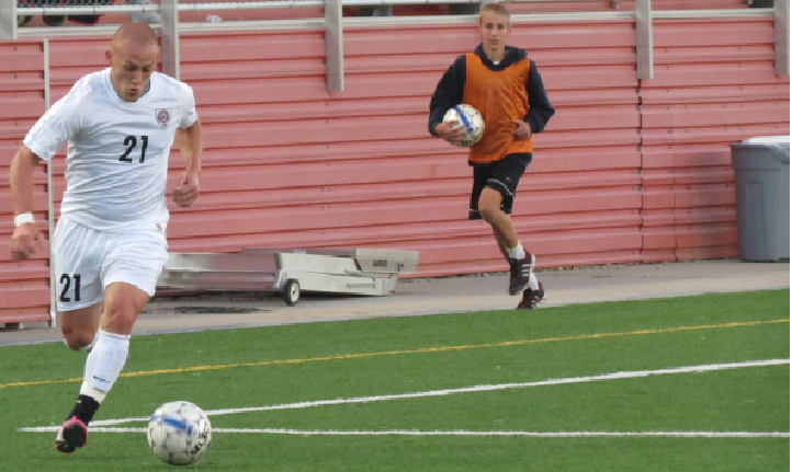 Clearing the  ball, defender Elías Galván (left) passes the ball to the middle fielder as Hastings College goes against Bellevue in the soccer season of 2013-14. Galván played with many different teams, but for college soccer, he played at Hastings in Nebraska. “The adrenaline you feel in games, and being part of something as big and beautiful as a team is the best part of soccer,” Galván said.