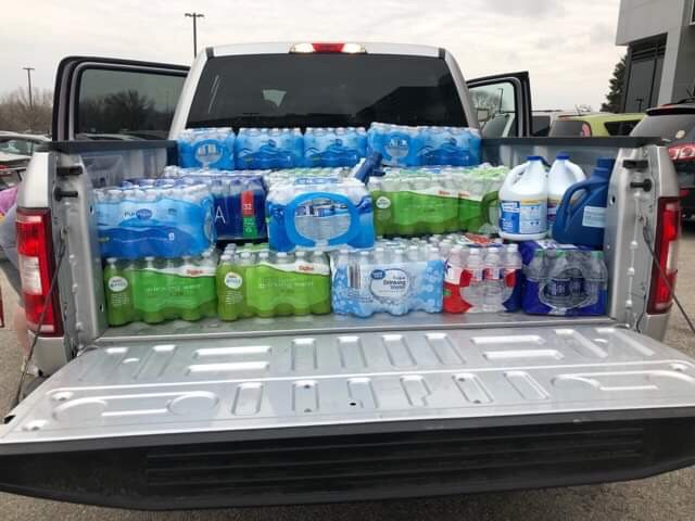 In an additional vehicle, junior Taylor Richman loads up cases of water to be donated to flood victims. 