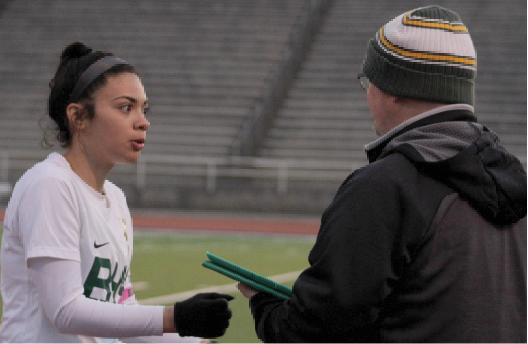 At the April 4, varsity girls soccer game against Marian, 2019 alumna  Angela Miranda gets advice from then, assistant coach Thomas Townsend. Miranda, who now plays for Bellevue University, played for Townsend for three years. “He encouraged me to continue playing because I was unsure and he believed that I was capable of playing at the next level which meant a lot,” Miranda said. “He was always there for anything including on and off the field. He knows the sport so well. It was an honor for me to get coached by him.”