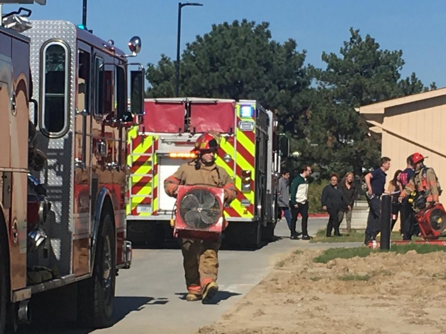 Bringing in fans, firefighters prepare to air out the burning plastic smell in the school caused by the cell phone that ignited.