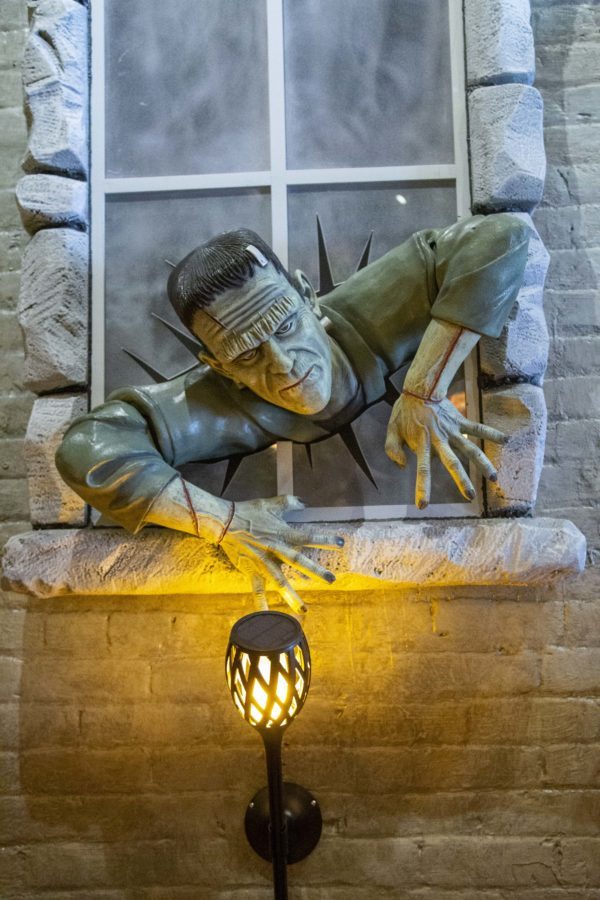 Breaking through the fake window on the wall of The Monster Club, Frankenstein and many other feature characters add to the Halloween decorations of the restaurant. 