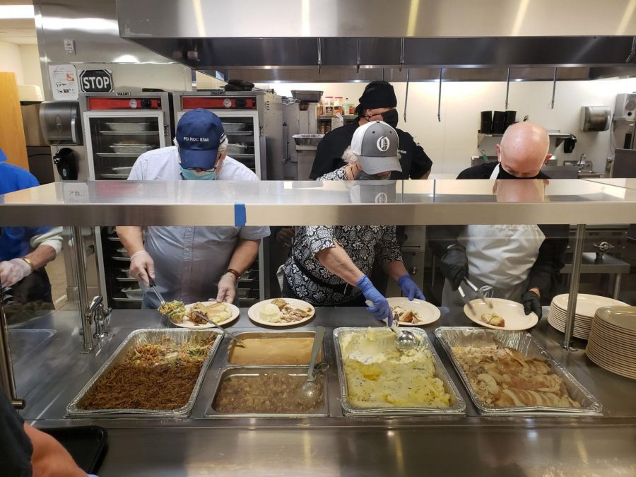 Dishing out food to serve to people at the Stephen Center on Thanksgiving, volunteers aid in the process of making plates. 