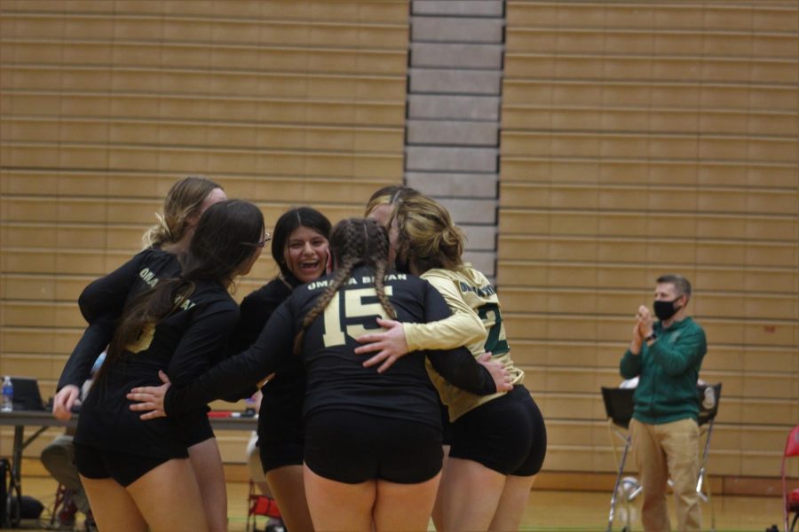 After scoring a point, the girls varsity volleyball team huddle together and congratulate themselves to boost each others energy and motivation. 