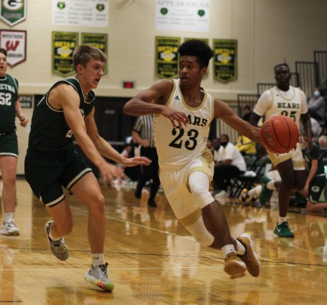 During the varsity basketball game against Gretna on Dec. 9, senior point guard Terril Brown dribbles down the court while trying to keep the ball away from his 
opponent, Gretna’s point guard, number 24 Alex Wilcoxson. The Bears went on to lose the game by a close margin of 45-47.