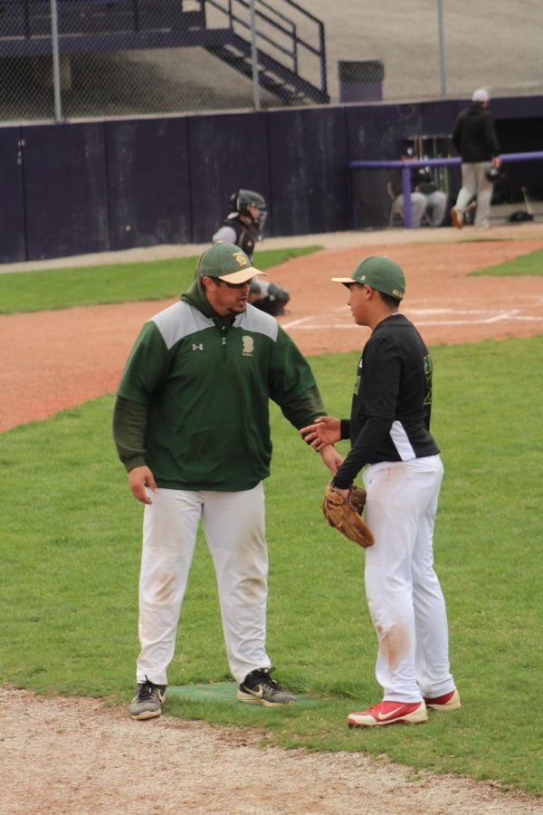 During the 2021 baseball season, head baseball coach Brian Kottich has
a quick pep talk with sophomore Omar Ramirez at first base before he
heads out to play defense at a game against Bellevue East.