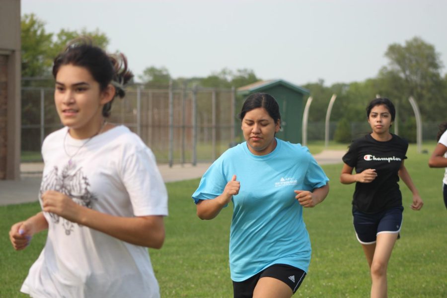 During soccer conditioning, seniors Diana Reyes and Jesenia Herenandez Ortega get their warm up run in before they start doing their soccer drills.