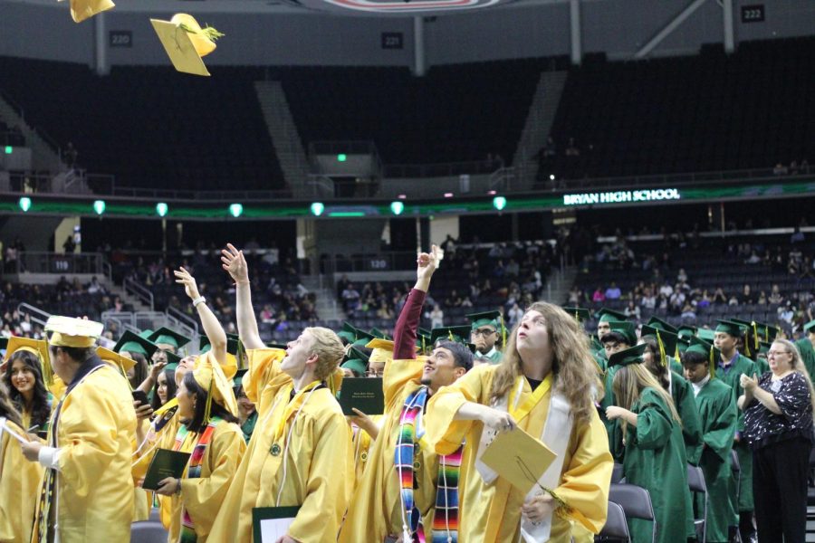 Seniors throwing their caps in the air to celebrate their graduation.