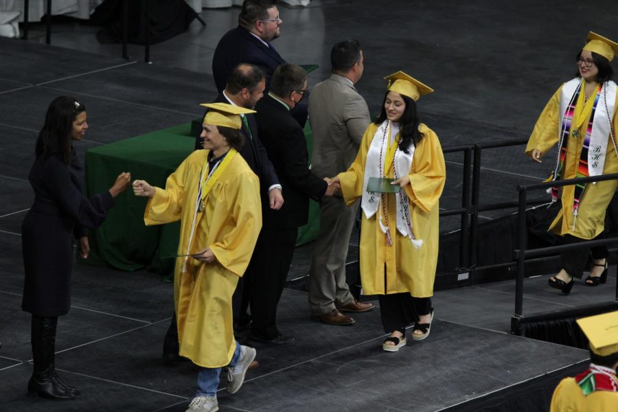 Seniors walking the stage to pick up their diploma.