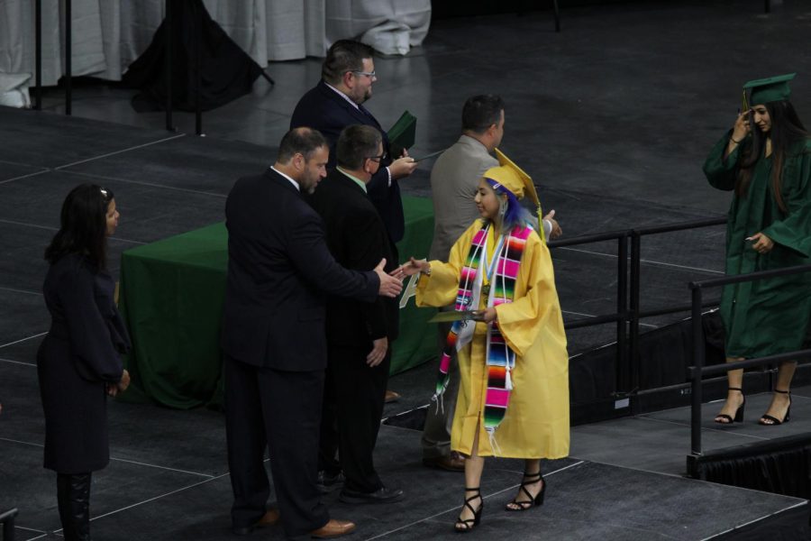Senior Jade Salgado shaking hands with admistrators after recieving her diploma.