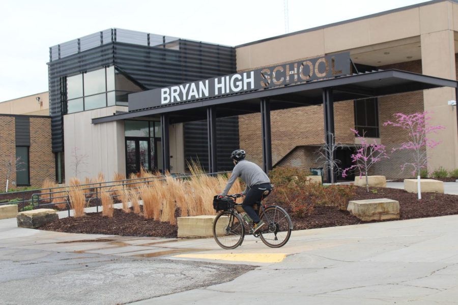Social studies teacher Nicholas Wennstedt rides his bike towards the back of the school on his way in. Wennstedt rides his bike to school in order to save gas since gas prices are high right now, and to help keep himself healthy and fit. 
