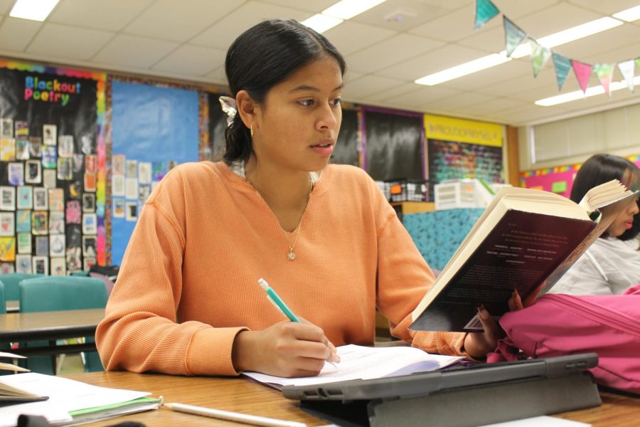 Senior Samantha Gomez-Estrada completes an English assignment with the book The Kite Runner. 

 