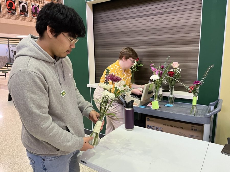 Senior Emanuel Lopez sets up the Urban Agricultures table to sell floral arrangements during lunch. 