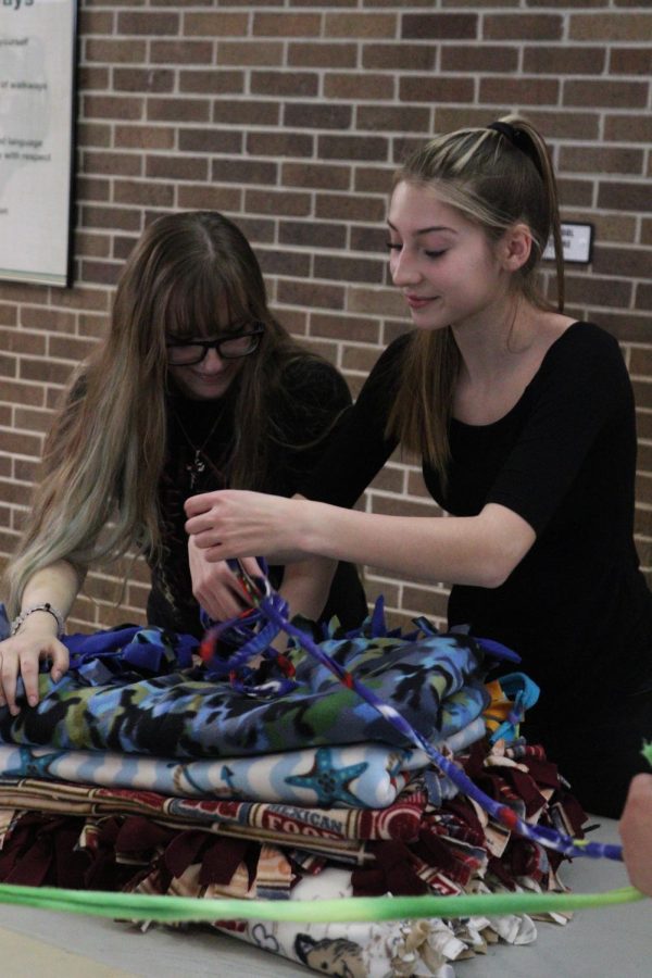 Juniors Abigail Jarrell and Sienna Stone tie a stack of blankets together. 