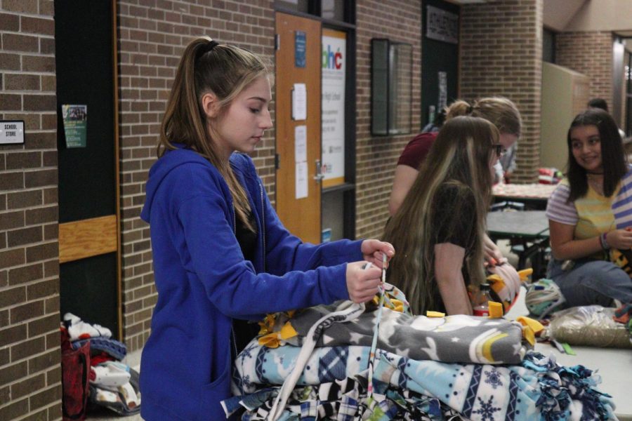 Junior Sienna Stone ties a stack of blankets together. 