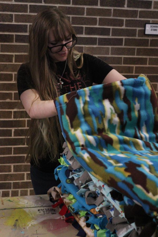 Junior Abigail Jarrell counts a stack of blankets before tieing them together. 