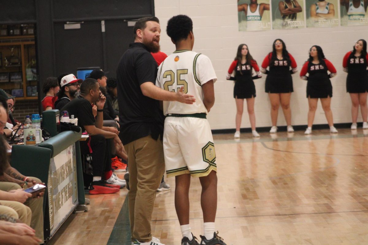 Varsity head coach Matthew Crouch talks to freshman guard Dominique Hairston during the basketball game versus South Jan. 24. This was Hairston's first game back due to wrist injuries. Bryan lost 70-48. Photo by Emiah Morris-Blackson