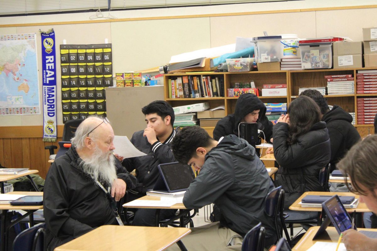 History teacher Thomas Allen helps sophomore Jared Perez with his in-class assignment about material culture, habits and taboos during B6 Human Geography on Feb.3. Photo by Emiah Morris-Blackson