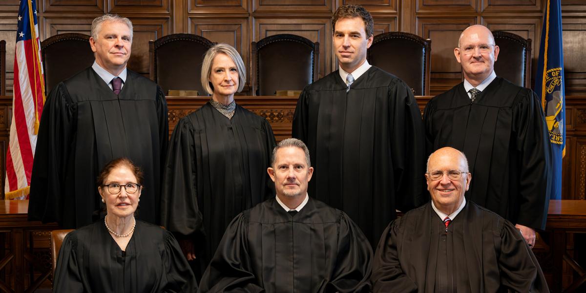 The justices in today’s trial are Jonathan Papik, Stephanie Stacy, Jeffrey Funke, John Freudenberg (Back), Lindsey Miller-Lerman, Mike Heavican, and William Cassel (Front). Photo by State of Nebraska Judicial Branch