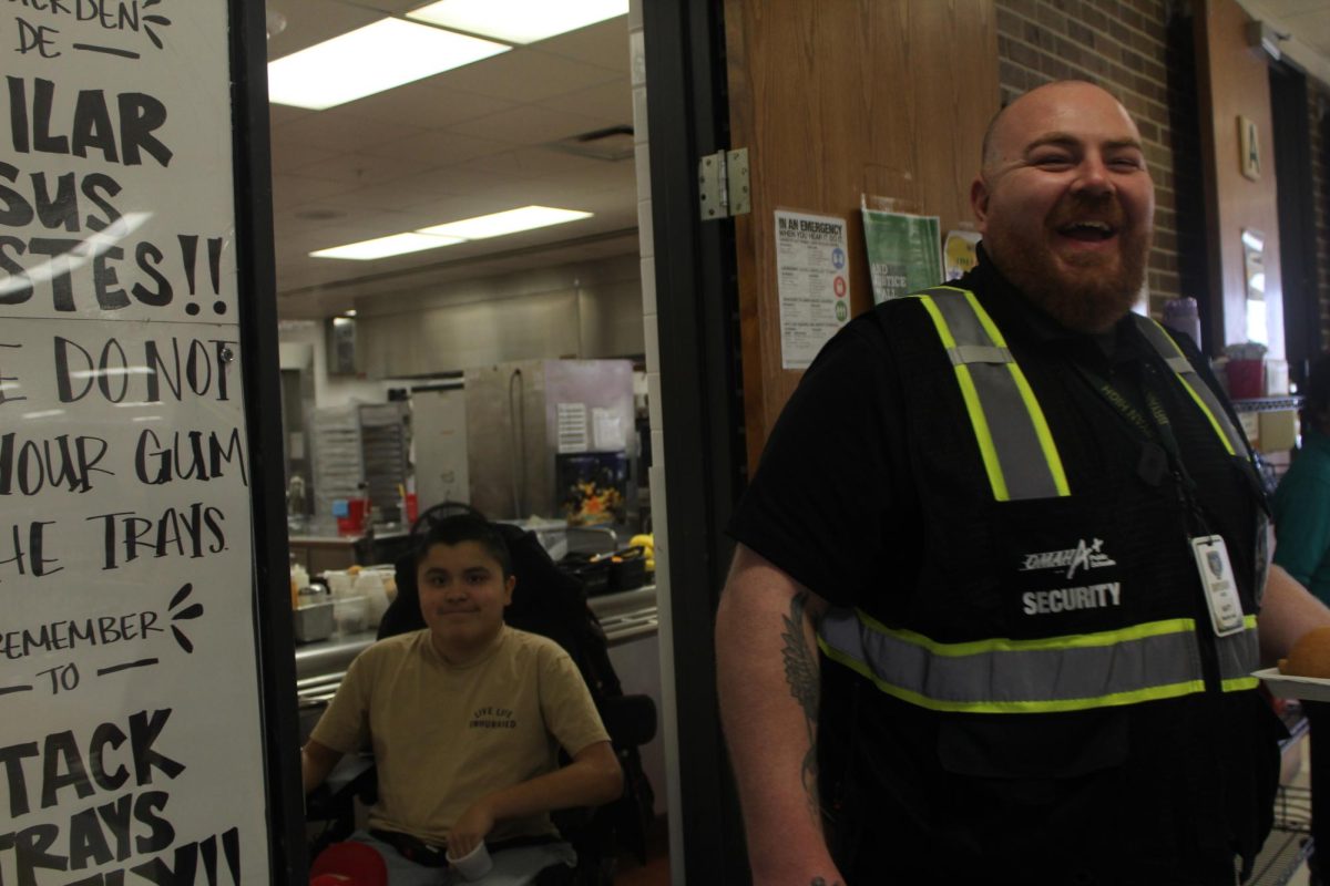 Security guard Ryan Katt assists senior Eder Carranza with his lunch. " It's everybody getting along that makes me happy," Katt said.