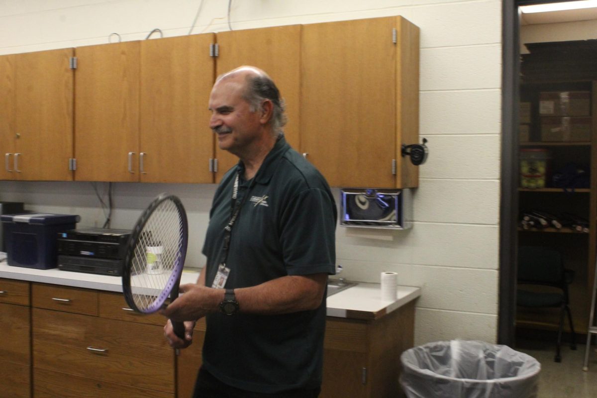 Business education teacher James (Mike) Gardner shows his A3 Info Technology Applications 2 class how to rewrap a tennis racket handle. Gardner plans on retiring after this school year. "I hope that students felt that they were treated fairly," Gardner said. Photo by Chiquita Hayes 