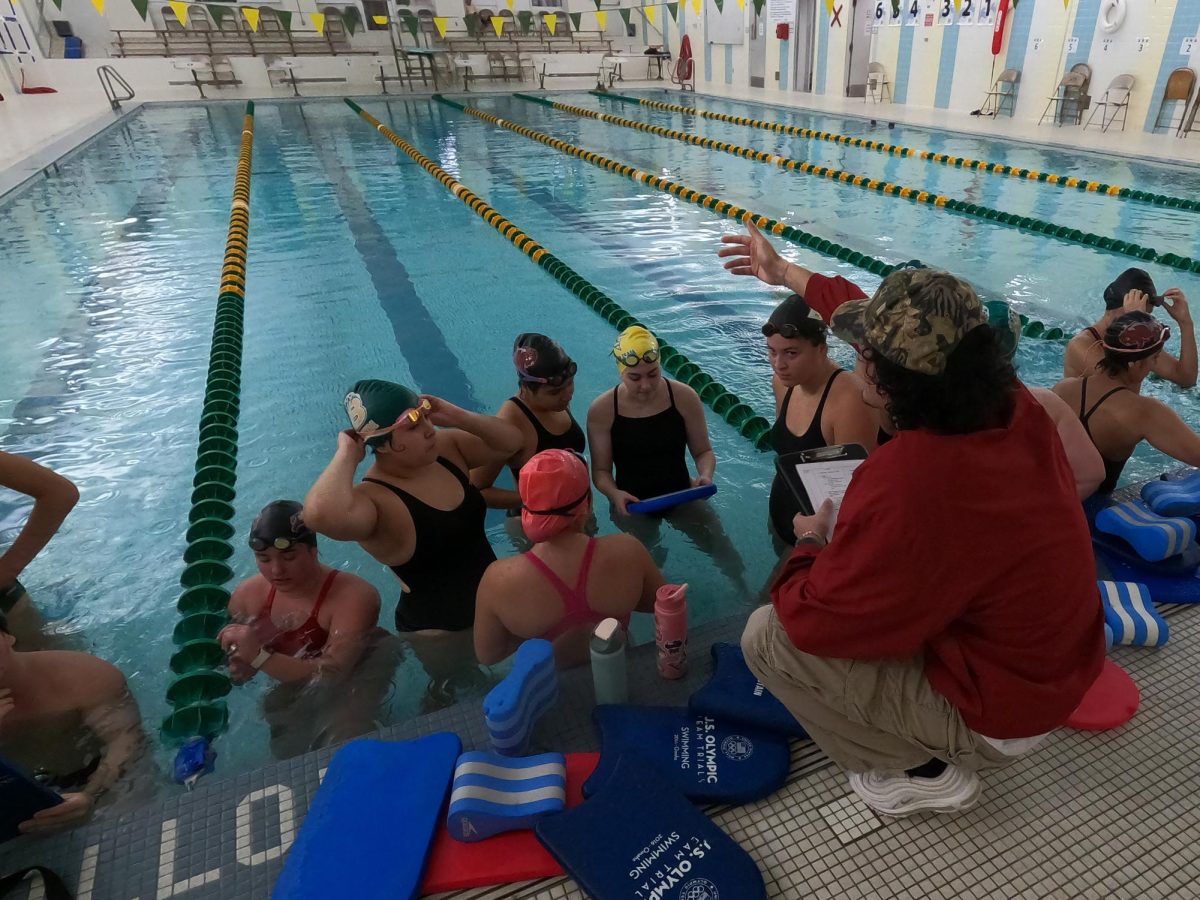 Gathered around head coach Nathan Moore, members of the swim team listen to him speak during practice Nov. 24.