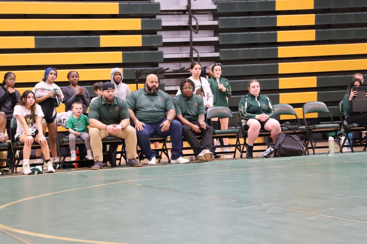 Assistant coaches Jared Gegzna, Eric Rice and Tavion Samuel watch as senior wrestlers compete on senior night Feb. 3.